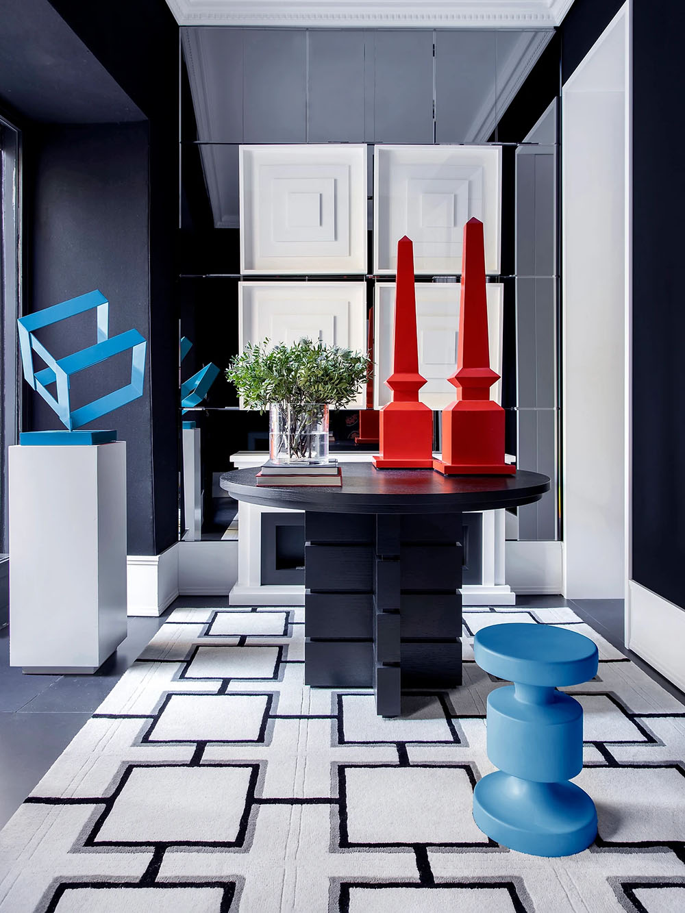 Interior salón. Decoración en tonos grises azulados con llamativos elementos azules y rojos.