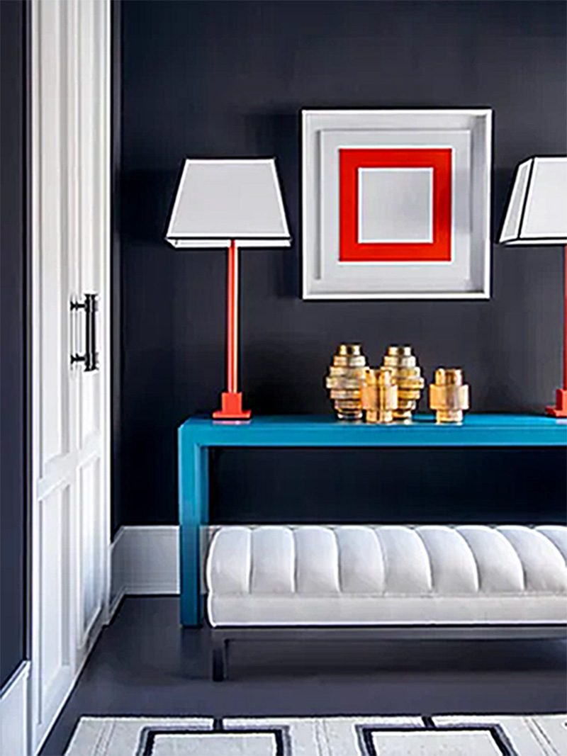 Interior salón. Decoración en tonos grises azulados con llamativos elementos azules y rojos.