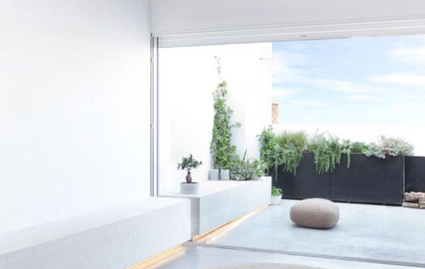 Vista interior a mirador exterior. Pareces blancas y suelo de cemento pulido.