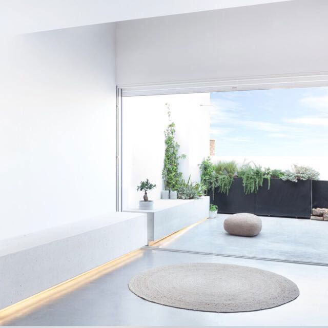 Vista interior a mirador exterior. Pareces blancas y suelo de cemento pulido.