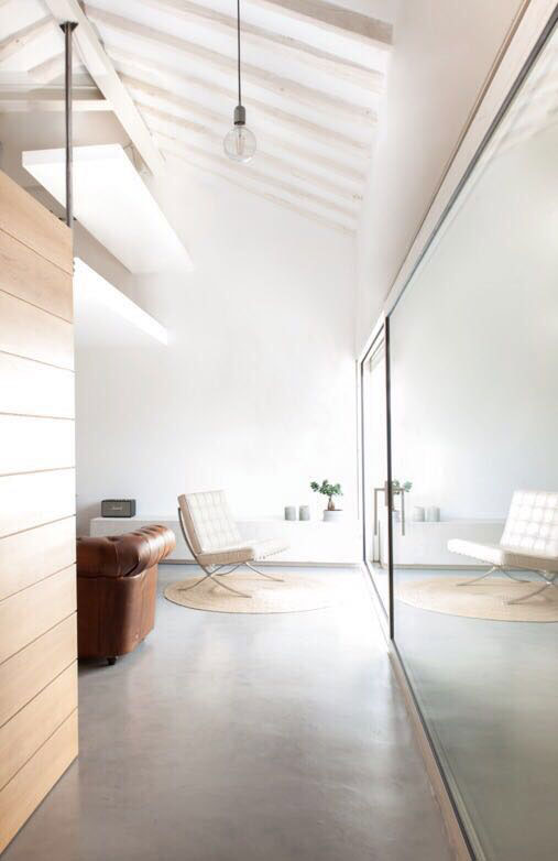 Interior espacio abierto. Acabado industrial en con techo a dos aguas y suelo de cemento pulido. Escalera de acero pulido.