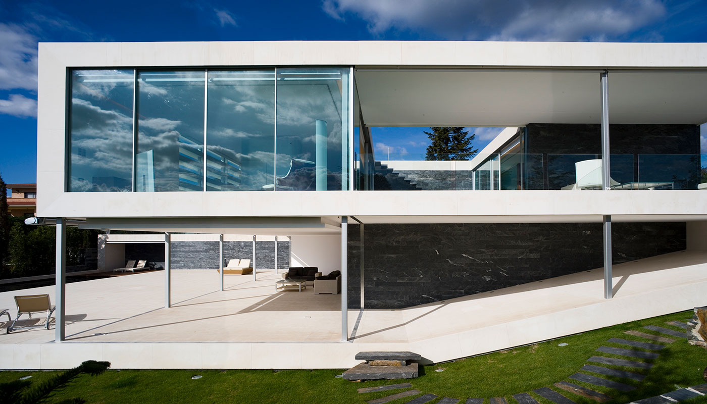 Exterior vivienda unifamiliar. Piedra caliza y cristal. Vista lateral.