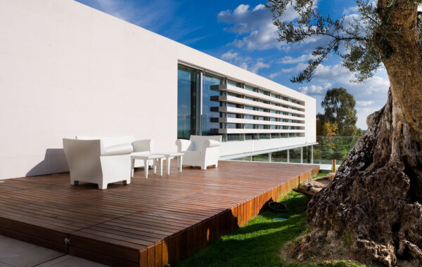 Exterior vivienda unifamiliar. Piedra caliza y cristal. Vista terraza superior trasera.