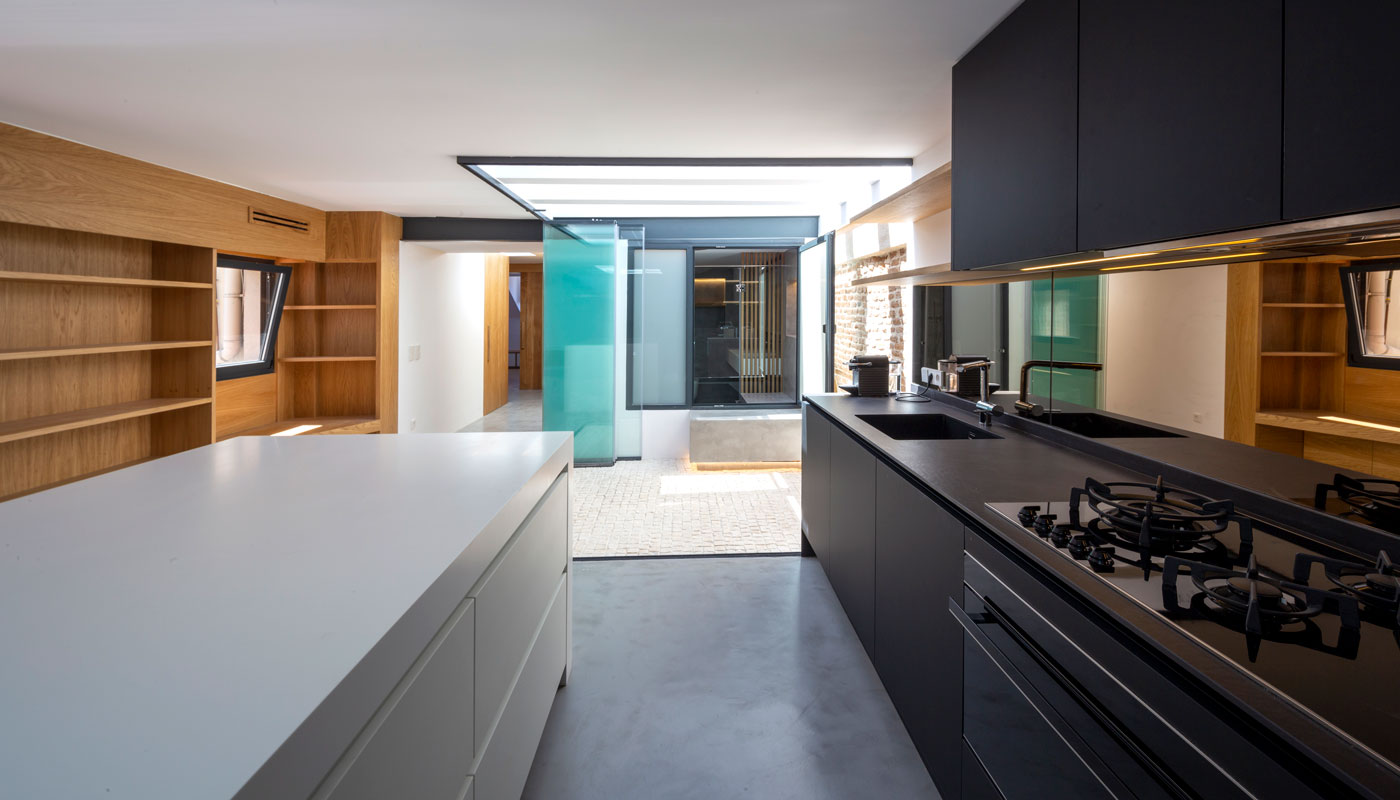 Vivienda interior. Cocina y patio acristalado al fondo.