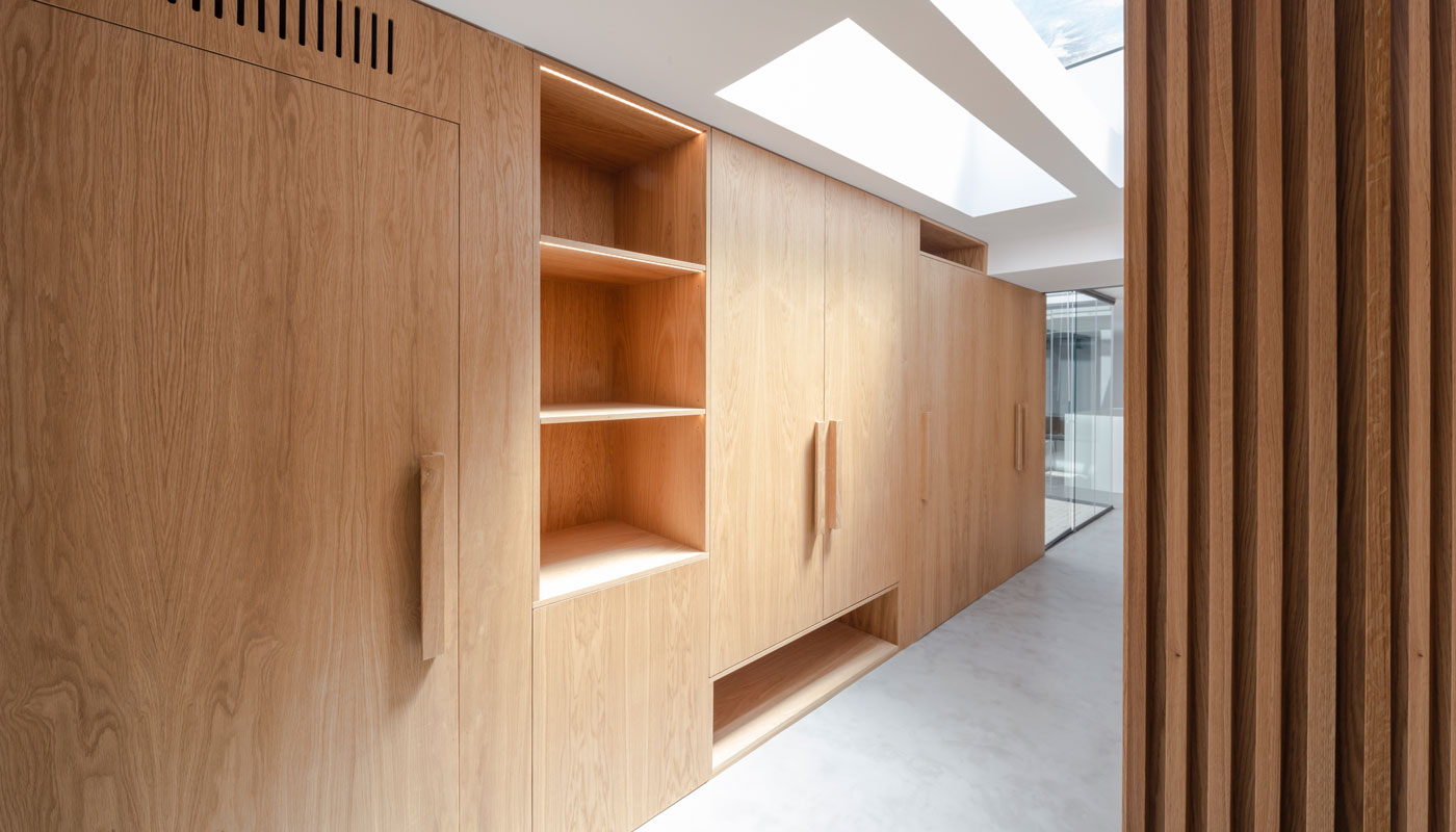 Vivienda interior. Detalle de pared de armarios en madera.