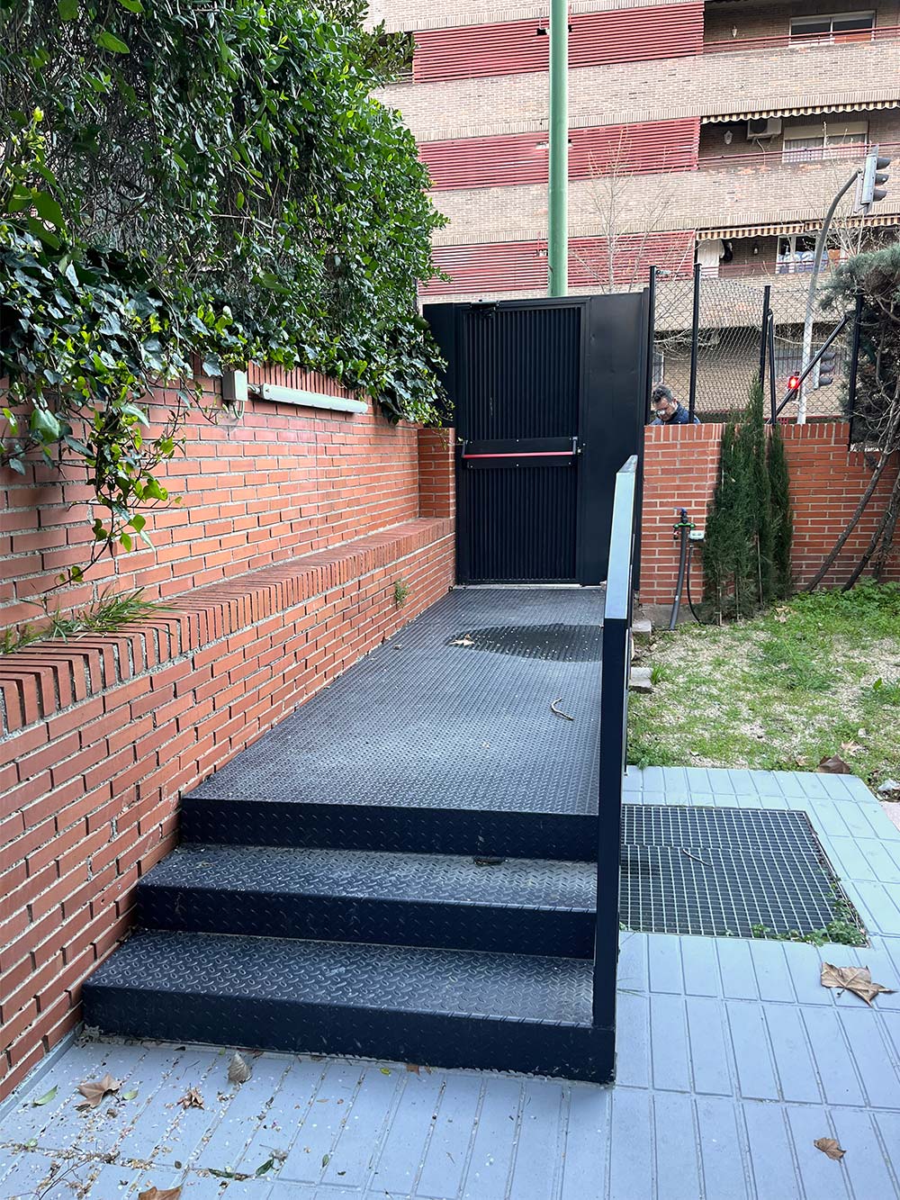 Exterior edificio escuela de ladrillo rojo. Detalle salida de emergencia.