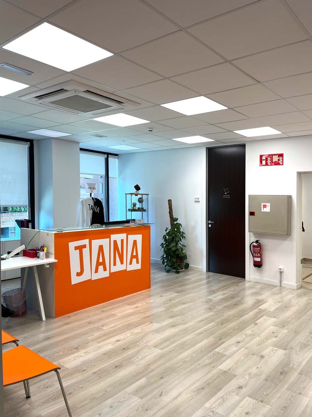 Interior, detalle de recepción con mostrador naranja.