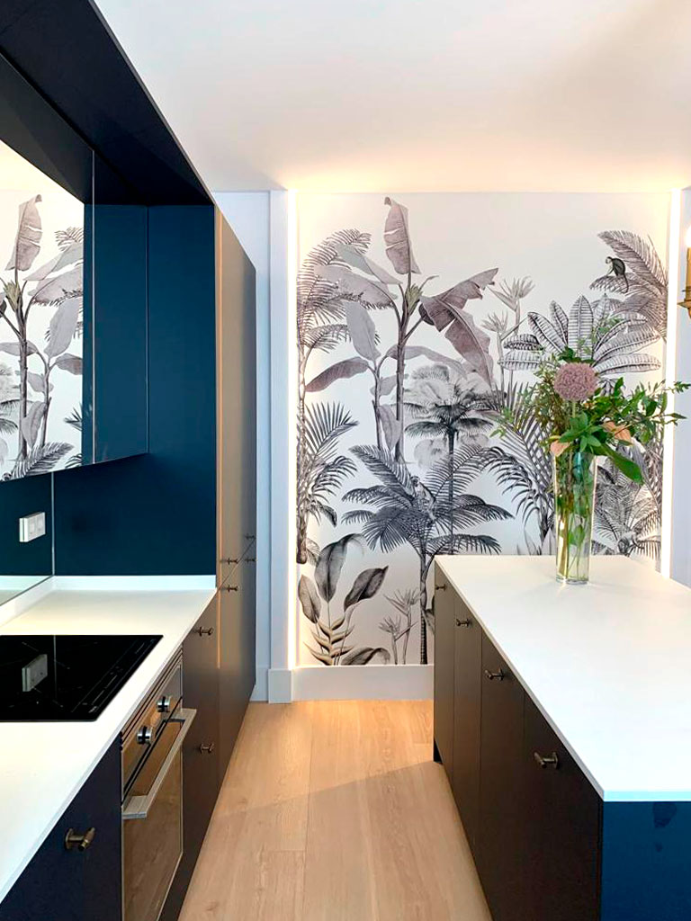 Vista cocina con paredes azules. Detalle de ilustración en la pared trasera.