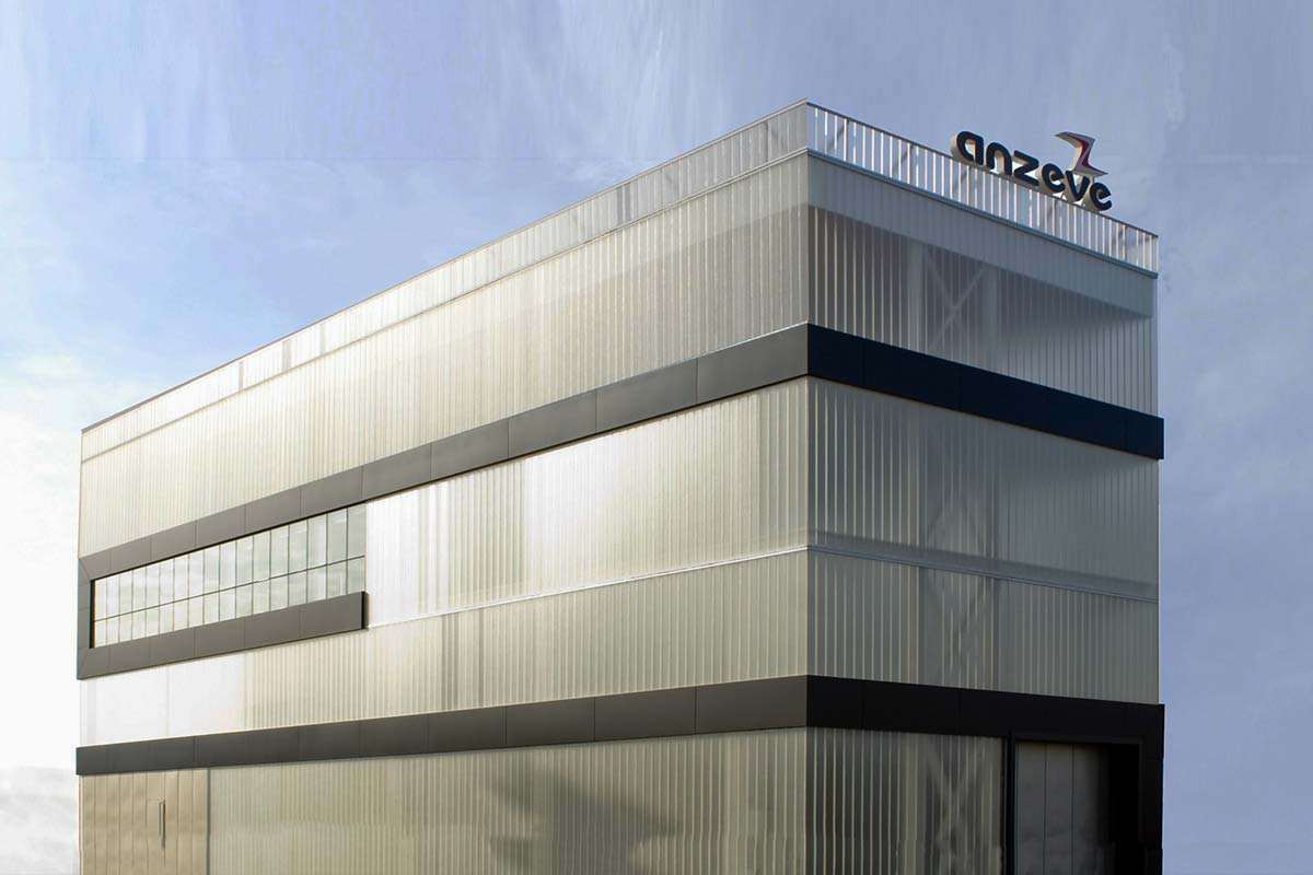 Exterior edificio de vidrio traslucido autoportante, piedra y metal.