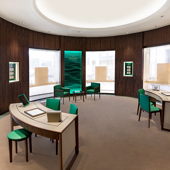 Interior joyería. Acabados en materiales nobles y sillas verdes.