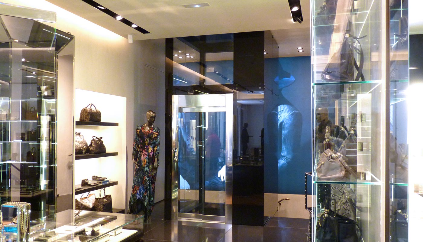 Tienda de moda. Vista interior. Materiales nobles con iluminación en perfiles.