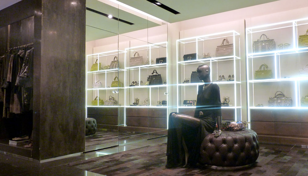 Tienda de moda. Vista interior. Materiales nobles con iluminación en perfiles.