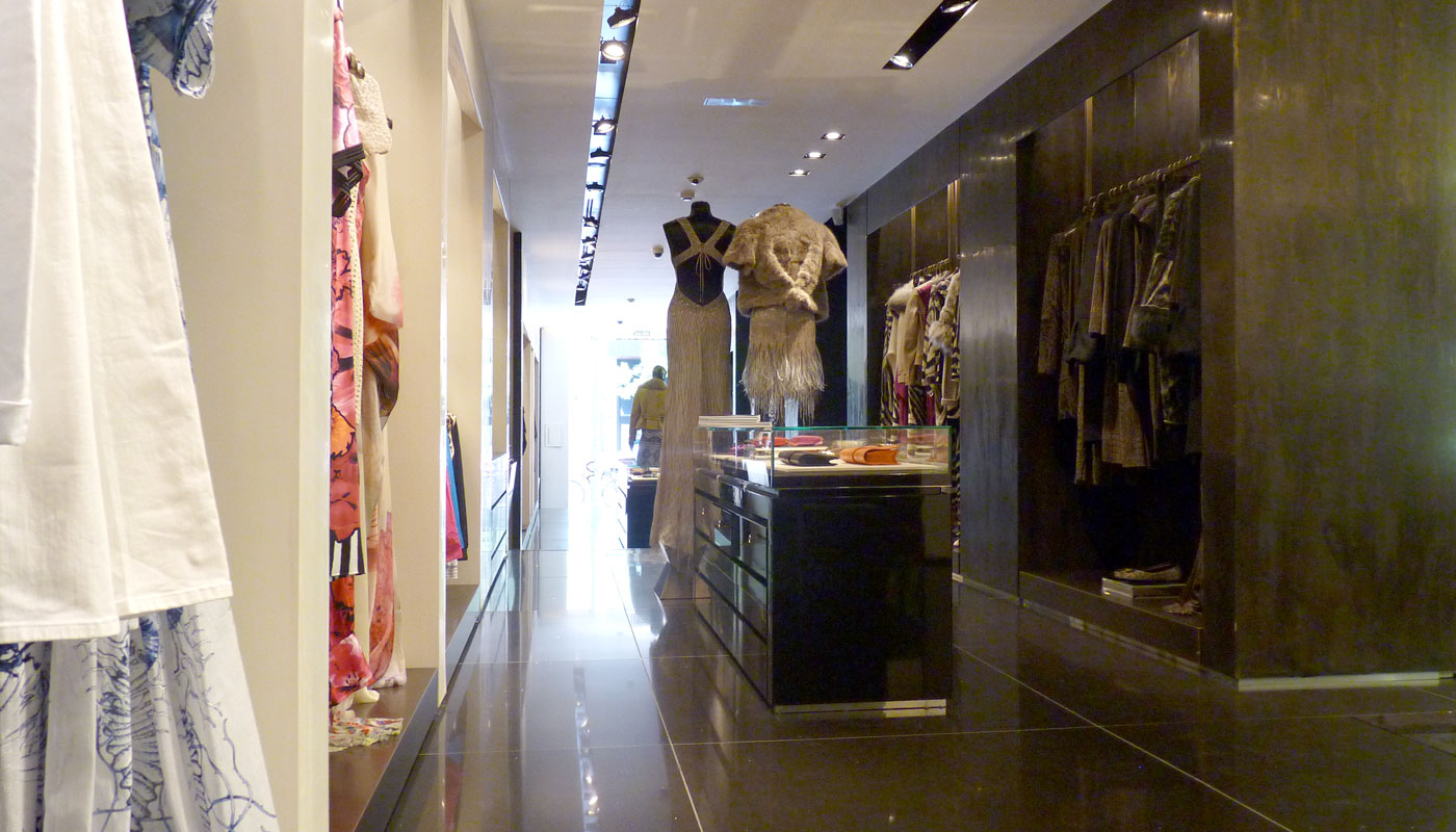 Tienda de moda. Vista interior. Materiales nobles con iluminación en perfiles.