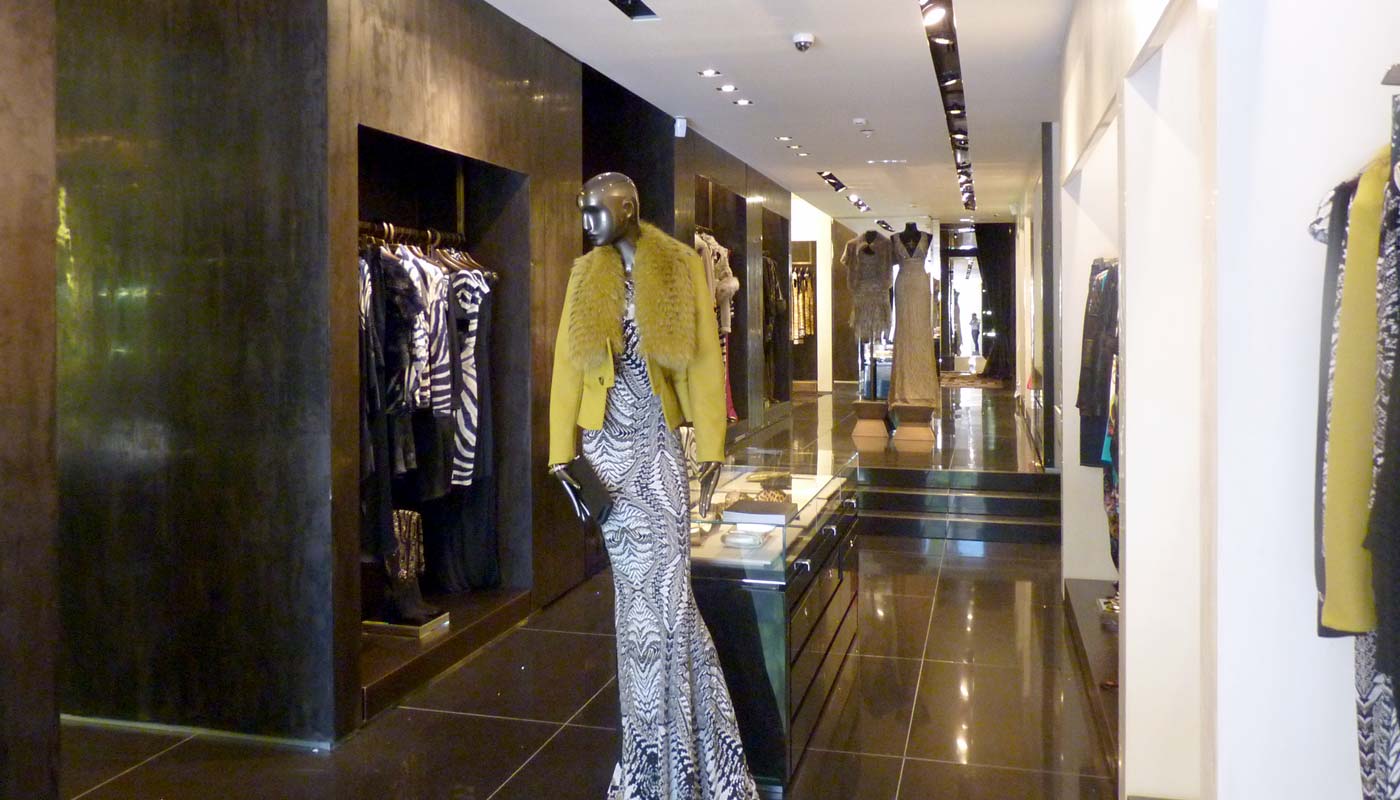 Tienda de moda. Vista interior. Materiales nobles con iluminación en perfiles.