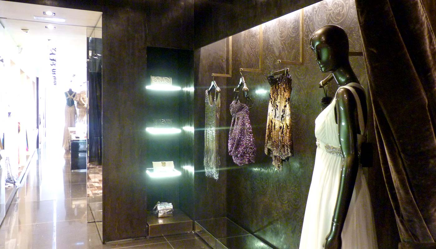 Tienda de moda. Vista interior. Materiales nobles con iluminación en perfiles.