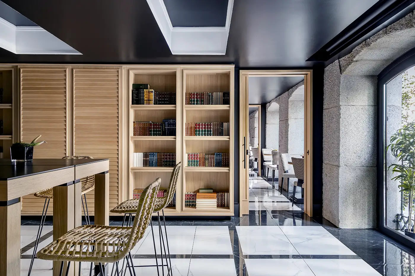 Interior restaurante. Vista frontal de carpintería de madera. Techos altos, abundante iluminación. Detalles en rojo y tapicerías en tonos azules.