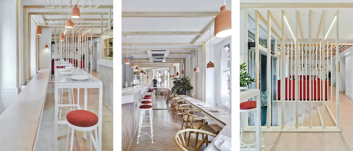 Planta superior de un luminoso restaurante. Decoración en tonos blancos y madera de color claro rematado con tapicería de color rojo anaranjado.