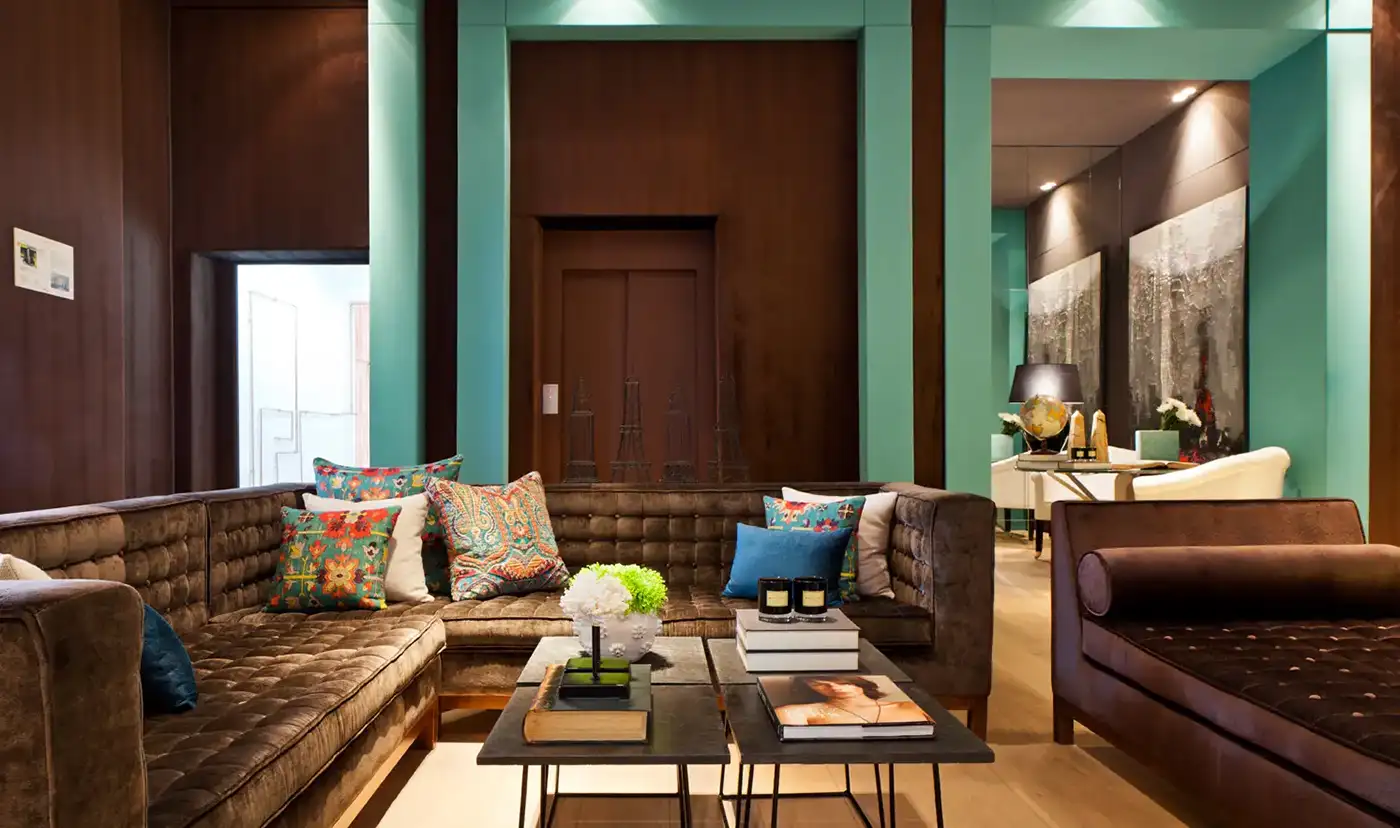 Vista interior de una estancia con suelo de madera y paramentos verticales acabados en color verde, madera y marmol negro.