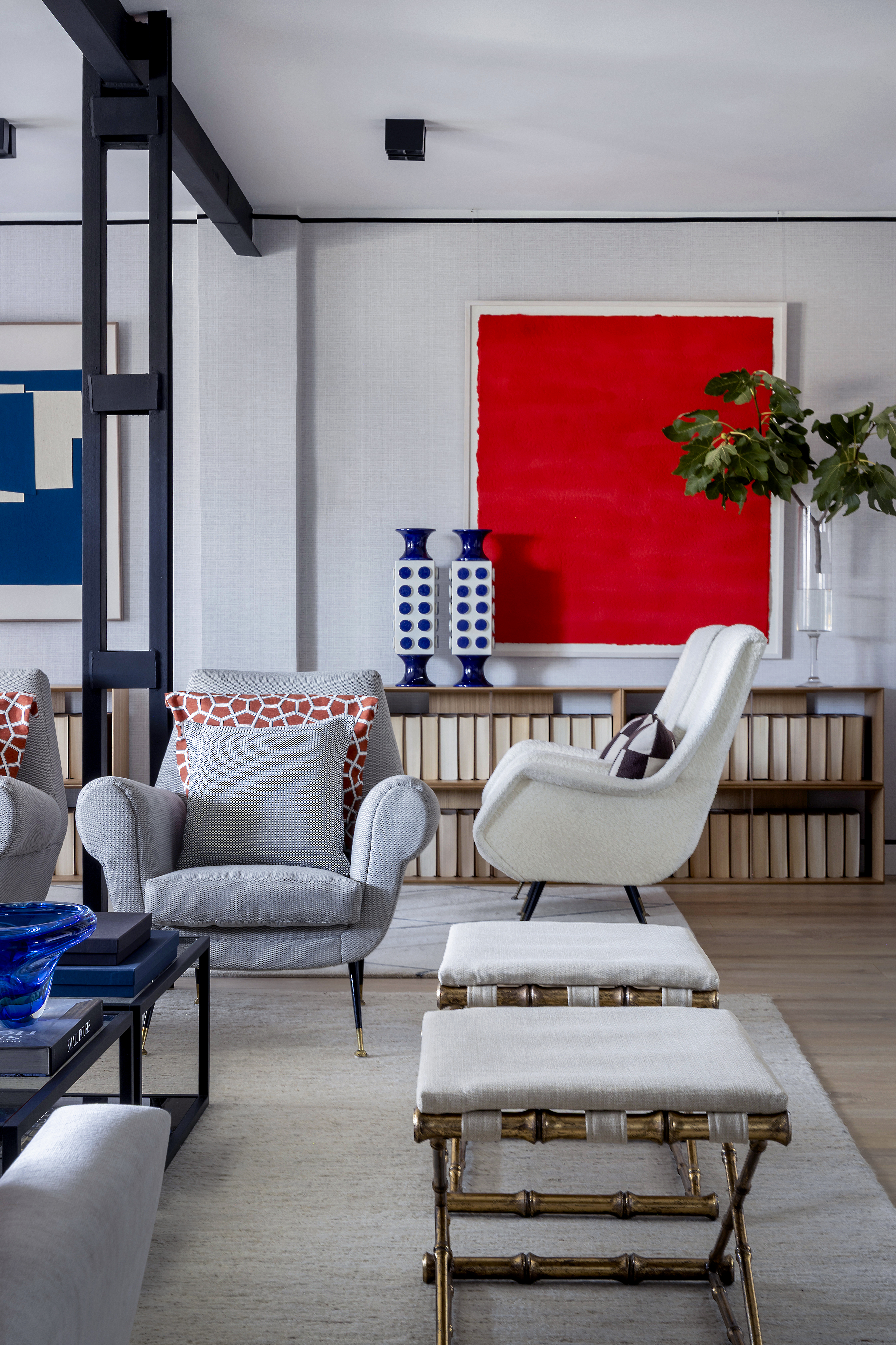 Zona de descanso del salón con butacas, reposapiés y obra de arte.